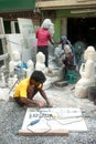 Burmese man carving a large marble Buddha statue.