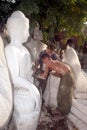 Burmese man carving a large marble Buddha statue.