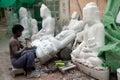 Burmese man carving a large marble Buddha statue.