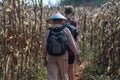 A burmese man in traditional clothing and a woman in a corn field