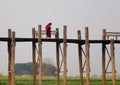 Burmese monks in red clothes walking on Ubein Bridge