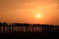 People crossing the longest teak bridge in the world, the iconic wooden U Bein Bridge during sunset, Mandalay, Myanmar