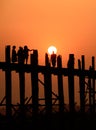 People crossing the longest teak bridge in the world, the iconic wooden U Bein Bridge during sunset, Mandalay, Myanmar Royalty Free Stock Photo