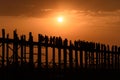 People crossing the longest teak bridge in the world, the iconic wooden U Bein Bridge during sunset, Mandalay, Myanmar Royalty Free Stock Photo