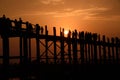 People crossing the longest teak bridge in the world, the iconic wooden U Bein Bridge during sunset, Mandalay, Myanmar Royalty Free Stock Photo