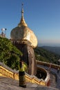 Burmese woman praying in front of the Kyaiktiyo Pagoda - Golden rock. She wears traditional longyi skirt. Sacred buddhist