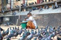 Burmese woman selling grains and seeds for pigeon food.