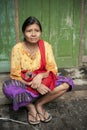 Burmese woman sitting in front of the door