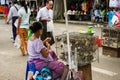 A Burmese woman, with Thanakha on her face, selling merit birds outside Shwedagon Pagoda, Yangon.