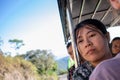 Burmese woman with traditional thanaka paste on her face. She is on an open transport, taking fresh air and thinking. Kyaikto,