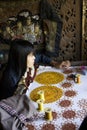 Burmese woman at work sewing beads