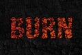 Burn lettering word from hot orange of burnt tree on black wood charcoal texture