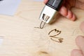 Burn out a drawing on a wooden board with an electric device with a scorcher Royalty Free Stock Photo