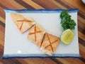 Burn salmon belly cut in cross shape on served with lemon lime and japanese vegetable leaf on a white plate in japanese style Royalty Free Stock Photo