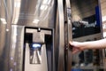 Close up of people trying a new fridge inside electronic store