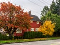 BURNABY, CANADA - October 24, 2018: House in residential area with yellow and red trees in autumn.