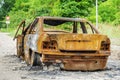 Burned down car wreck before crossroad Royalty Free Stock Photo