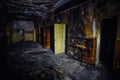 Burned by fire interior of old hospital. Charred walls and doors of corridor