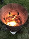 Almost burned out Easter fire. Glowing embers in a metal barrel. Campfire or campfire in a metal barrel. Ghetto street fire in