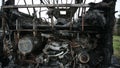 Burned-out passenger bus on the side of the road