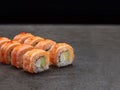 Burned Salmon Tataki sushi roll with avocado and cream cheese on dark concrete background Royalty Free Stock Photo