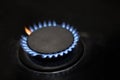 Burner with flame in the dark, closeup. Blue and red flame. Gas supply to the house