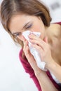 burnette woman blowing nose into tissue