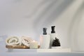 Aromatic candle, towels and shampoo bottles on white table. Spa accessories. Royalty Free Stock Photo