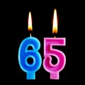 Burning birthday candles in the form of 65 sixty ive figures for cake isolated on black background. The concept of celebrating a b Royalty Free Stock Photo