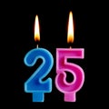 Burning birthday candles in the form of 25 twenty five figures for cake on black background. The concept of celebrating a