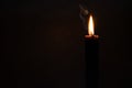 Burning black thin candle for a magical ritual, Halloween or occultism