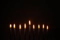 Burning blue candles on a Jewish menorah at Hanukkah on a dark brown background