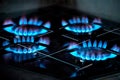 Burning blue flames gas. Focus on the front edge of the gas burners. Gas burners on a home stove. Gas crisis. Royalty Free Stock Photo