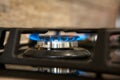 Burning blue gas on the dark stove. Burner gas stove, concept of energy. Closeup, selective focus Royalty Free Stock Photo