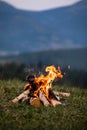 Burning bonfire in the evening in the Carpathian mountains. Place for inscription