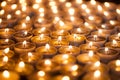 Burning bright. Golden warm glow from candle flames. Many beautiful lit tealight candles glowing.