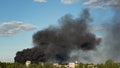 Burning building with black smoke. Huge smoke clouds after explosion