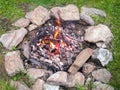 Burning campfire in a meadow surrounded by stones Royalty Free Stock Photo