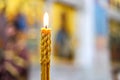 A burning candle against a background of blurred icons in an Orthodox church. Royalty Free Stock Photo
