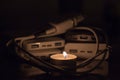 A burning candle against the background of power banks and a charger Royalty Free Stock Photo