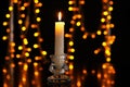 Burning candle against blurred lights Royalty Free Stock Photo