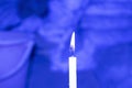 Burning candle on a blue background, close-up Royalty Free Stock Photo