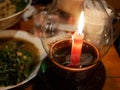 Burning candle in a candle glass holder on a dinning table at ni Royalty Free Stock Photo