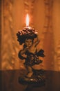 A candle glowing in a candlestand statue in church Royalty Free Stock Photo