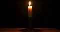 Burning candle in candlestick on black background Royalty Free Stock Photo