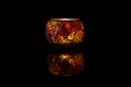 Burning candle in a candlestick on a black background with reflection Royalty Free Stock Photo