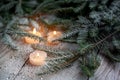 Burning candle and Christmas decoration over snow with pine branches on white wooden background Royalty Free Stock Photo