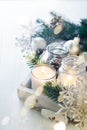 Burning candle and Christmas decoration over snow and wooden background, elegant low-key shot with festive mood Royalty Free Stock Photo