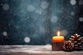 Burning candle, Christmas decoration on wooden background in falling snow and defocused lights background. Royalty Free Stock Photo