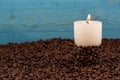 Burning candle among coffee beans Royalty Free Stock Photo